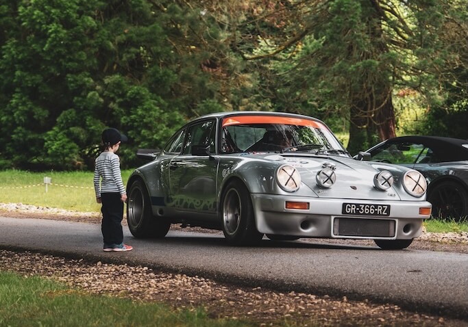 Un enfant devant une Porsche 911 Turbo