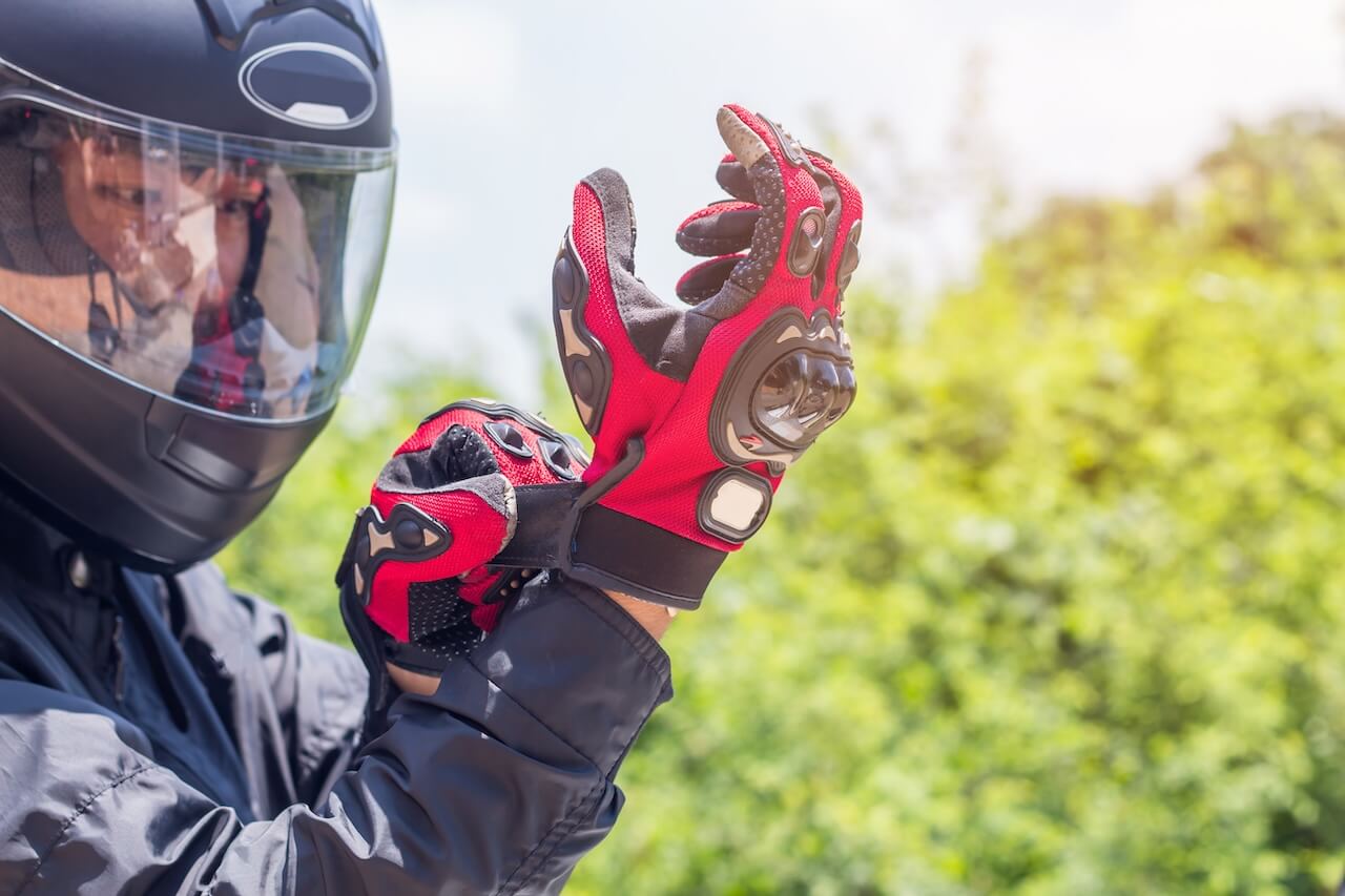 un motard qui attache ses gants