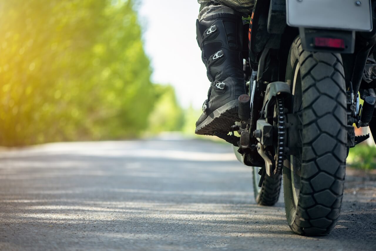 la jambe d'un motard assis sur sa moto