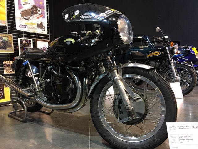 Visiteurs admirant les véhicules anciens au salon.