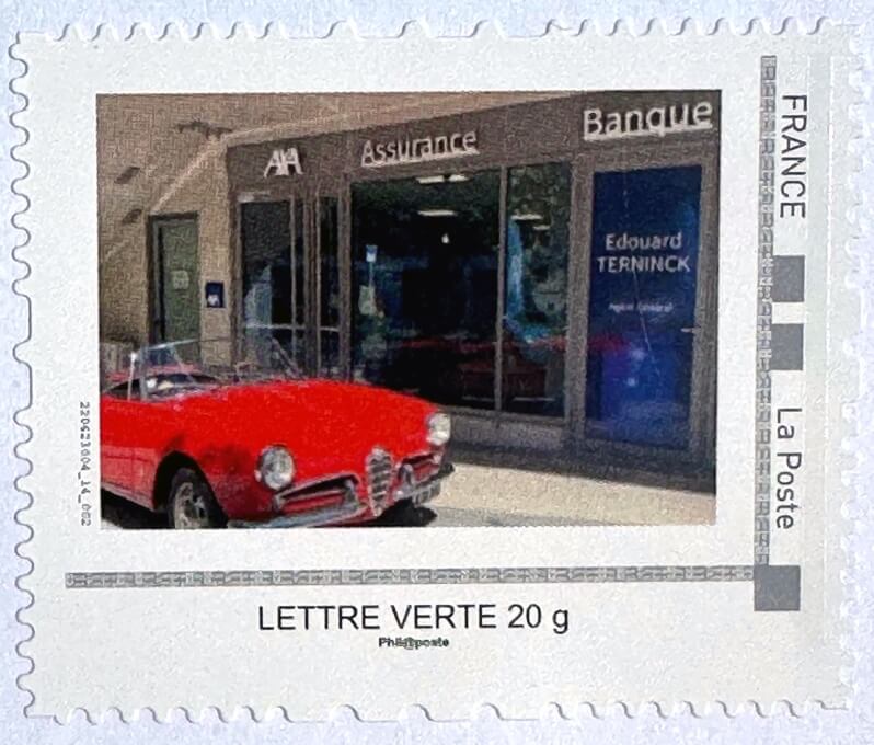 Timbre édité par l’agence d’Edouard Terninck : Alfa Romeo Giuletta 1961, garée devant l’agence de Juan-les-Pins.
