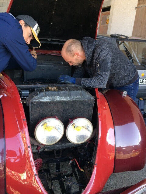 Collectionneurs réparant une panne lors d'un rallye.