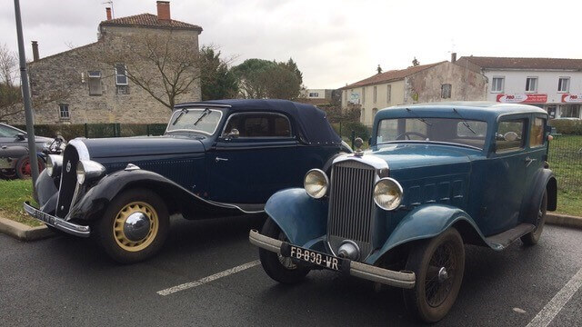 Voiture ancienne en panne sur le bord de la route.
