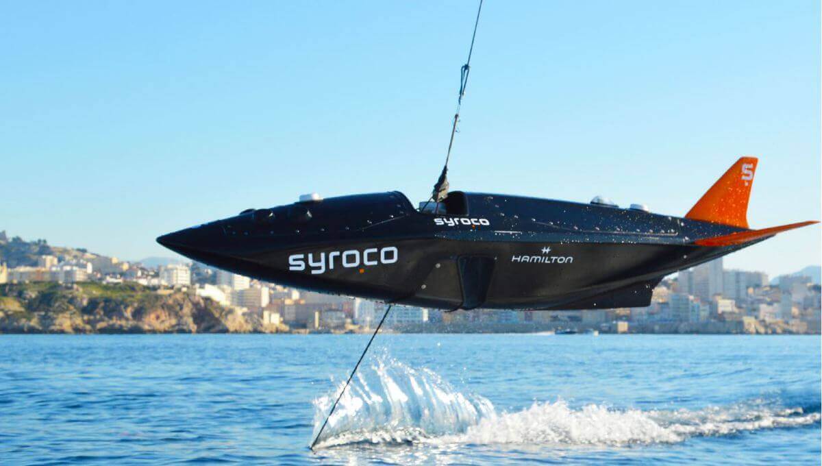 La nacelle Syroco en vol au-dessus de l'eau en rade de Marseille.